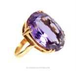 A LARGE 9CT GOLD AND AMETHYST RING. Having a large oval cut amethyst set in a geometric style