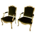 A pair of Louis XV, style, cream-painted, parcel gilt, open armchairs