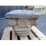A weathered carved stone capital in the Classical taste