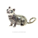 A cast silver figure of a cat with emerald eyes.