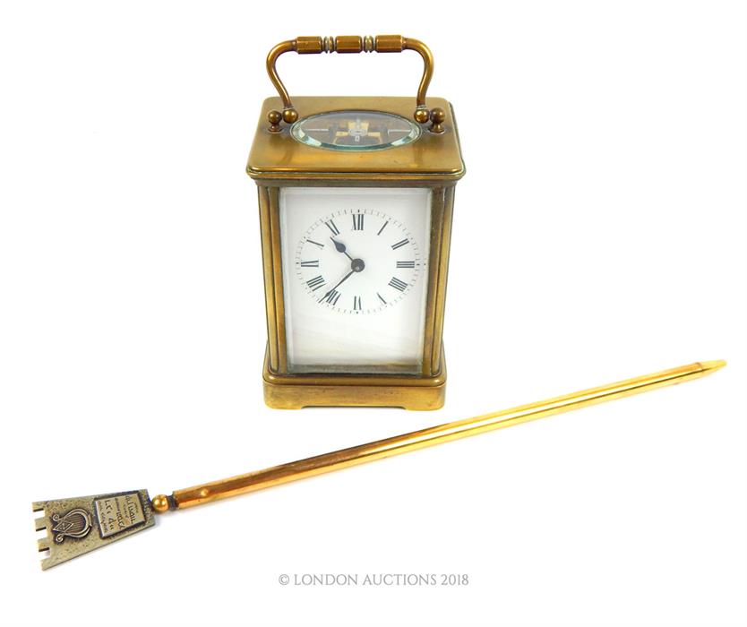 A brass carriage clock with a brass page turner engraved 'Danny Kaye'