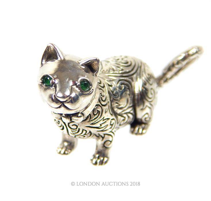 A cast silver figure of a cat with emerald eyes. - Image 2 of 2