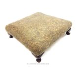 A large, square, low stool with a neutral, paisley upholstery