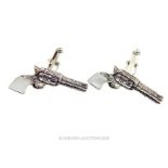 A pair of silver cuff-links in the shape of pistols with mother of pearl handles