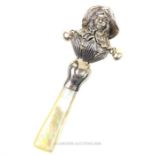 A silver baby rattle with mother of pearl handle