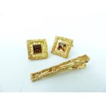 A pair of gold plated cufflinks and a tie bar