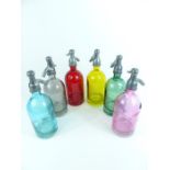 A set of six, brightly-coloured glass, models of soda siphons