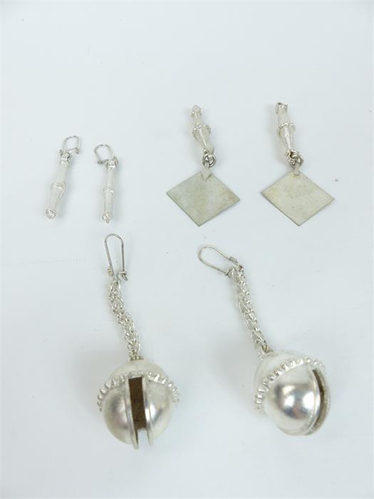 Three pairs of white metal earrings