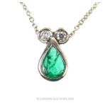 An 18 ct white gold, diamond and emerald pendant and chain