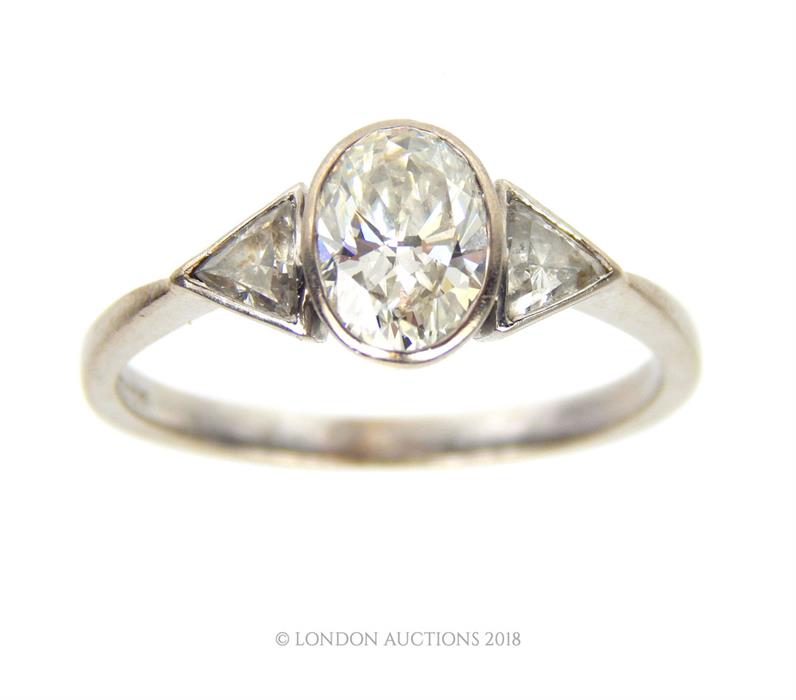 An 18 ct white gold, oval-shaped diamond ring