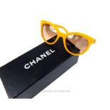 A boxed pair of Chanel, yellow framed sunglasses