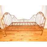 A large, wrought-iron, French, day bed on brass casters