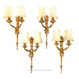 Four twin branch, gilded brass wall lamps