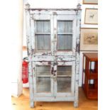 An antique, painted and distressed display cabinet