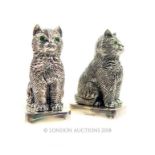 A pair of 800 silver, cat condiments with emerald-set eyes