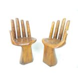 A pair of hardwood chairs in the form of open hands