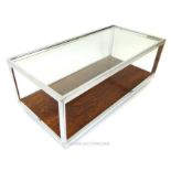 A chromed and glass two tier low coffee table