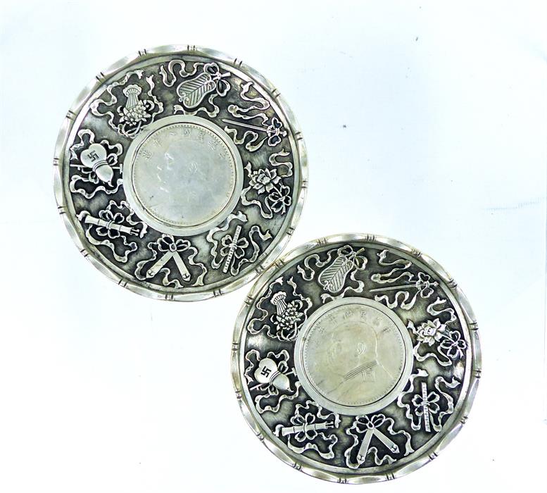 A pair of Chinese white metal dishes, inset with Chinese coins