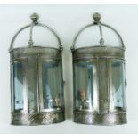 A pair of chromed, wall-mounted, candle holders