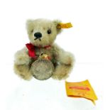 A Steiff teddy bear (button in ear and labels) with a silver coin pendant