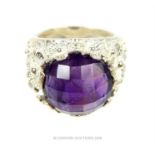 A substantial, sterling silver, floral ring set with a faceted amethyst