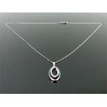 A boxed, 10 ct white gold, blue and white diamond pendant on a gold chain