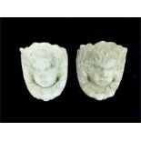 A pair of stone composite, wall pockets in the form of cherub faces