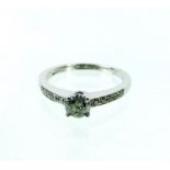 A 9 ct white gold, diamond solitaire ring with diamond set shoulders (0.50 carats)