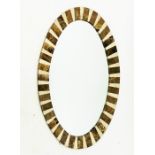 An oval mirror inlaid with panels of brown and white marble