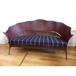 A vintage, French, woven-cane backed sofa with tartan-upholstered seat