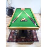 A large, billiards table (slate bed , green-felt upholstery)