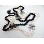 A long strand of freshwater pearls and black glass beads