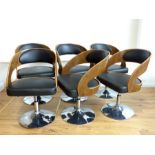 A set of six plywood and black faux leather swivel chairs