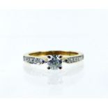 A 9 ct yellow gold diamond solitaire ring with diamond shoulders