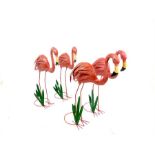 A flamboyance of four painted metal sculptures of flamingos