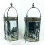 A pair of chromed, wall-mounted, candle holders