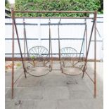 A painted and distressed metal garden swing