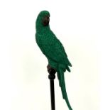 A large, decorative, green parrot on metal stand