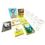A collection of signed golfing books and drinking glasses