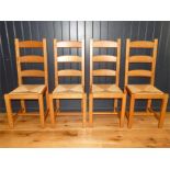 A set of four contemporary oak ladder back dinning chairs
