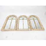 A set of three distressed rounded arch mirrors