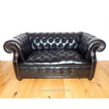 A black leather Chesterfield sofa to seat two