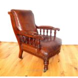 A Victorian walnut armchair, upholstered in brown leather