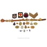 A collection of millitary cap badges, a hate belt etc