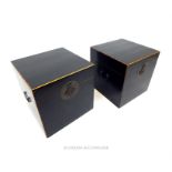 A pair of black-lacquered, cube-shaped storage boxes