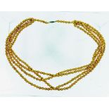 A gold-coloured necklace composed of four strands of Venetian glass beads