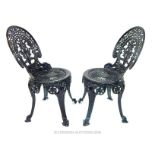 A pair of black painted aluminium garden chairs