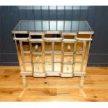 A contemporary double break front mirrored chest