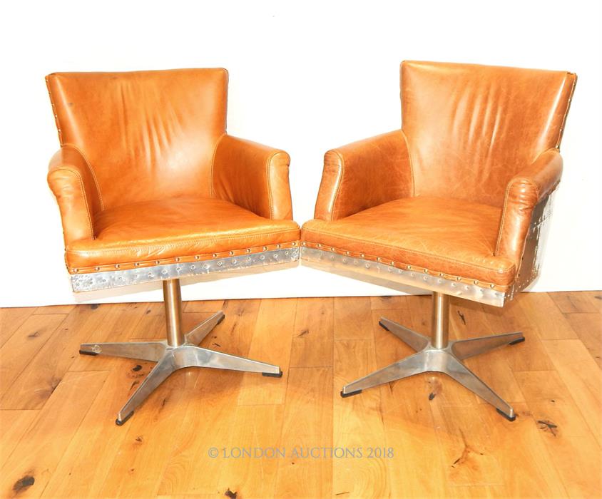 A pair of Aviator style aluminium swivel chairs