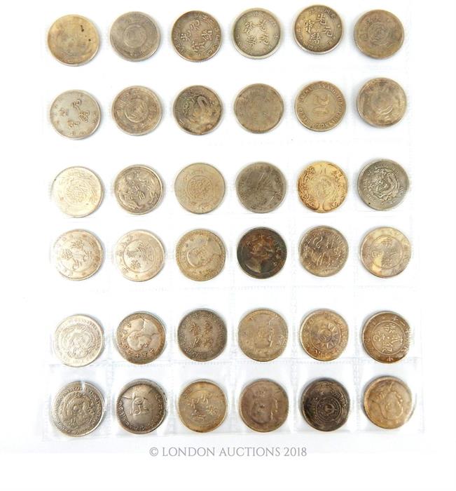 A collection of various Chinese white metal coins